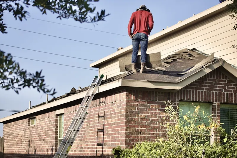 Professional roofer working on a residential roof in Willet